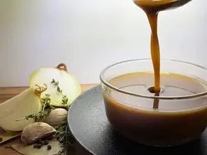 pouring gluten-free brown sauce into a glass bowl