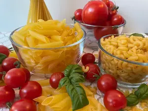 medley of gluten free pasta displayed with tomato and basil