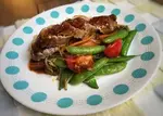 maple glazed pork tenderloin plated with sauteed vegetables