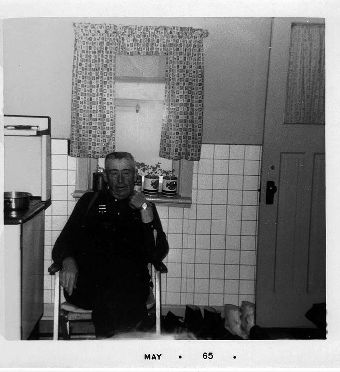 Harry Quirk in the kitchen beside the wood stove at Quirk's farm, Bancroft, Ontario, Canada.