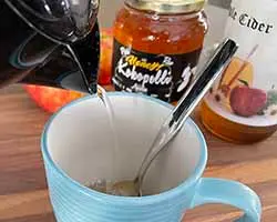 pouring hot water into a cup with apple cider vinegar