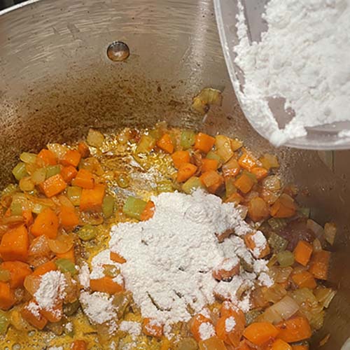 adding flour to butter and vegetables