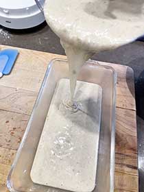 pouring banana bread batter into loaf pan