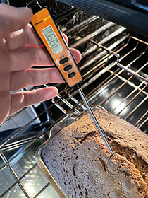 testing banana bread for doneness with digital thermometer