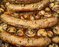 sausages braising in pan with mushrooms