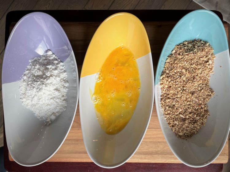 breading station - 3 bowls with gluten free flour, egg and ground almonds and pecans. breading station - 3 bowls with gluten free flour, egg and ground almonds and pecans.