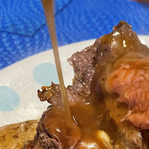 brown sauce pouring over roast beef