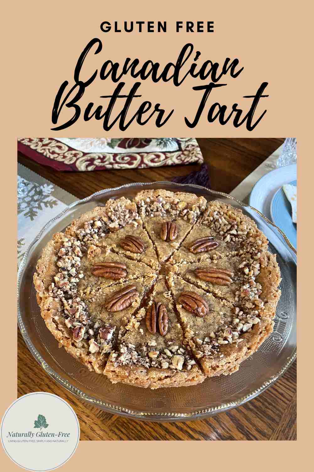 Pin Image - Gluten Free Canadian Butter Tart on a beautiful glass plate with Christmas decorations in background.