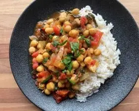 chana masala with white rice on black plate chana masala with white rice on black plate