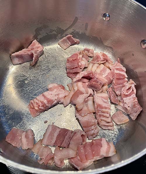 diced bacon frying in pot diced bacon frying in pot