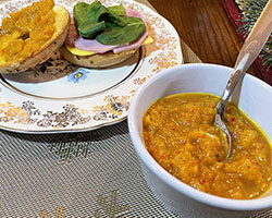 naturally gluten free curry pineapple chutney in white bowl with bagel in background