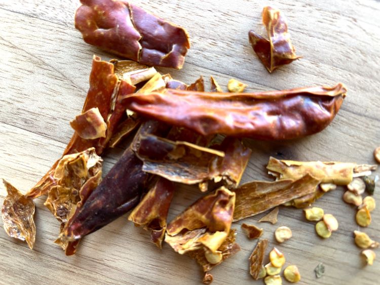 dried chili peppers on a wooden board