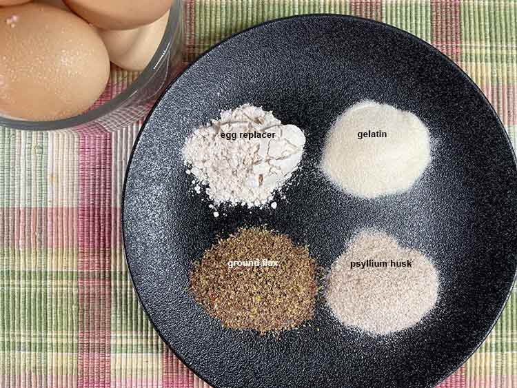 egg substitutes on black plate.  Commercial eggs replacer, gelatin, psyllium husk, ground flax