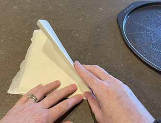 hands folding a piece of parchment
