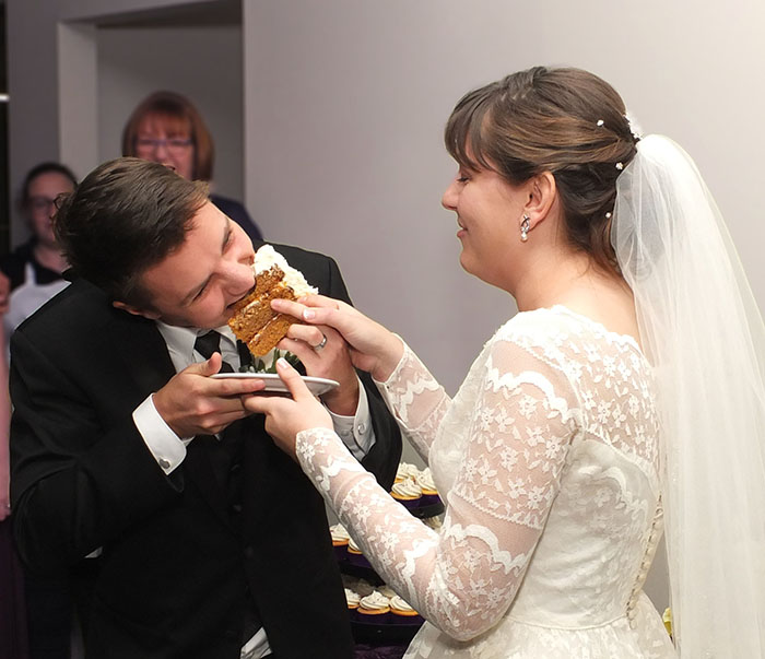 bride feeding gluten-free carrot cake to groom. bride feeding gluten-free carrot cake to groom.