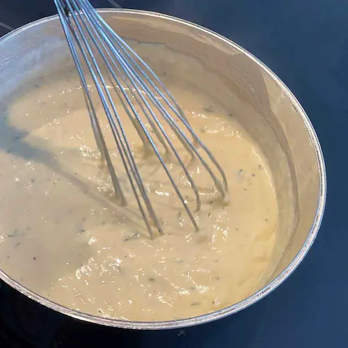 gluten-free béchamel in saucepan with whisk