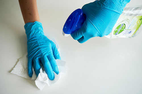 gloved hands cleaning with a spray cleaner.
Photo by Anton Uniqueton: https://www.pexels.com/photo/person-wearing-blue-gloves-cleaning-4021256/