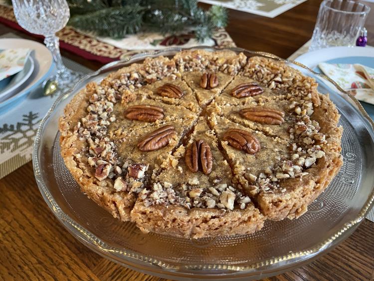 gluten free canadian butter tart on a beautiful glass cake pan with Christmas decorations in the background. gluten free canadian butter tart on a beautiful glass cake pan with Christmas decorations in the background.