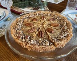 gluten free butter tart decorated with pecans on decorative plate