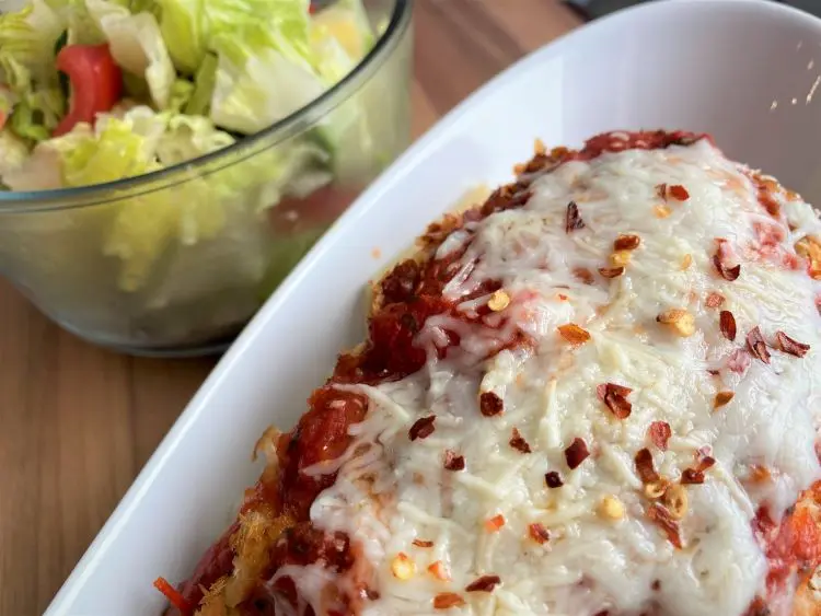 close up of chicken parm with side salad close up of chicken parm with side salad