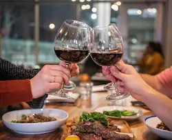 glasses raised over a table of gluten-free food