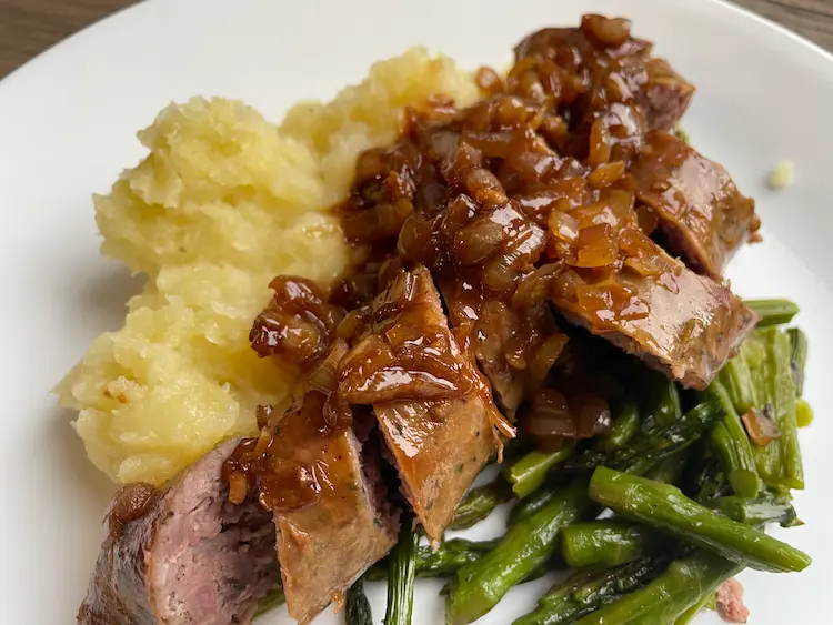 gluten-free sausage plated with mashed potatoes and pan sauce
