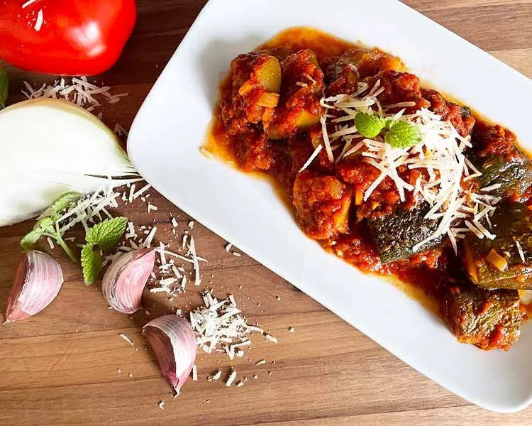 greek zucchini stew on white plate with garlic and onion greek zucchini stew on white plate with garlic and onion