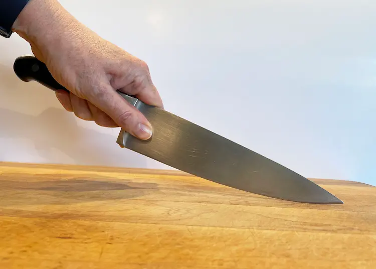 hand holding a chef's knife hand holding a chef's knife