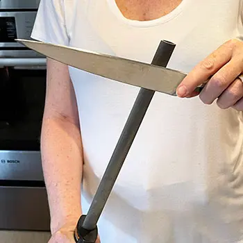 cook honing a chef's knife cook honing a chef's knife