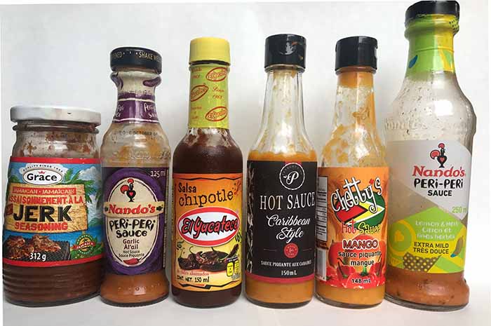 A variety of hot sauces. Left to right: jerk, peri peri, chipotle, Jamaican hot sauce, mango, herb and garlic peri peri. A variety of hot sauces. Left to right: jerk, peri peri, chipotle, Jamaican hot sauce, mango, herb and garlic peri peri.