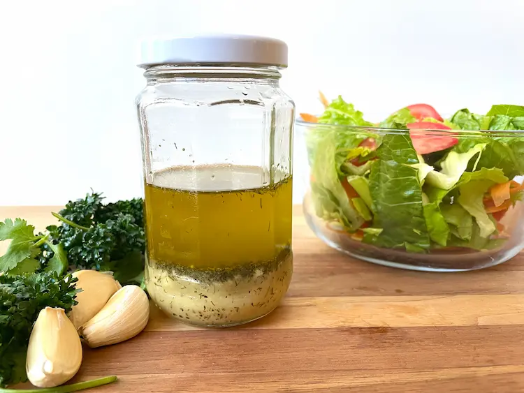 gluten-free salad dressing in a jar with lemon, lime and herbs