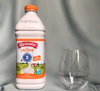 bottle of lactose free milk with empty glass bottle of lactose free milk with empty glass