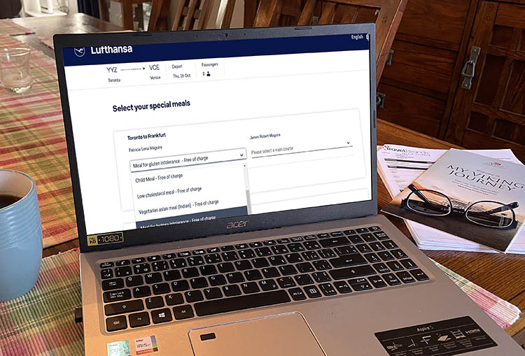 laptop with meal booking, coffee, travel documents, glasses laptop with meal booking, coffee, travel documents, glasses