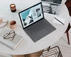 laptop on table with coffee and glasses