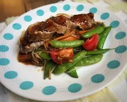 Gluten-Free Meals: Sliced pork tenderloin with maple sauce, green peas in pods and tomatoes on a white plate with teal spots around the edge. Gluten-Free Meals: Sliced pork tenderloin with maple sauce, green peas in pods and tomatoes on a white plate with teal spots around the edge.