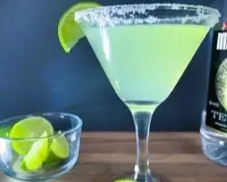 margarita in a martini glass with lime beside tequila bottle margarita in a martini glass with lime beside tequila bottle