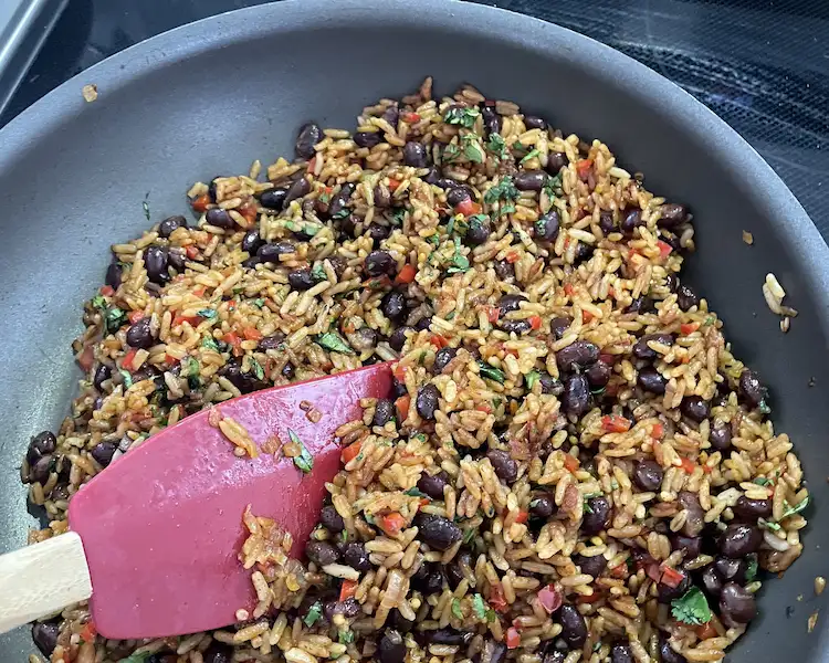 stirring Mexican rice in pan stirring Mexican rice in pan