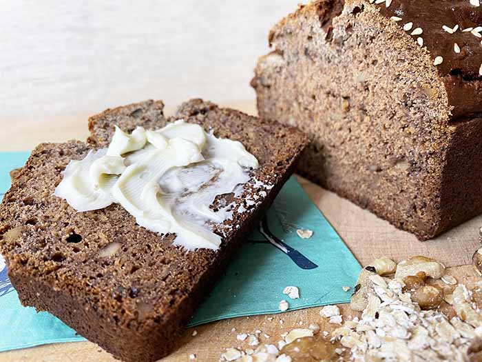 Naturally Gluten-Free Bread: Loaf of gluten free oat bread with one buttered slice on a teal napkin. Naturally Gluten-Free Bread: Loaf of gluten free oat bread with one buttered slice on a teal napkin.