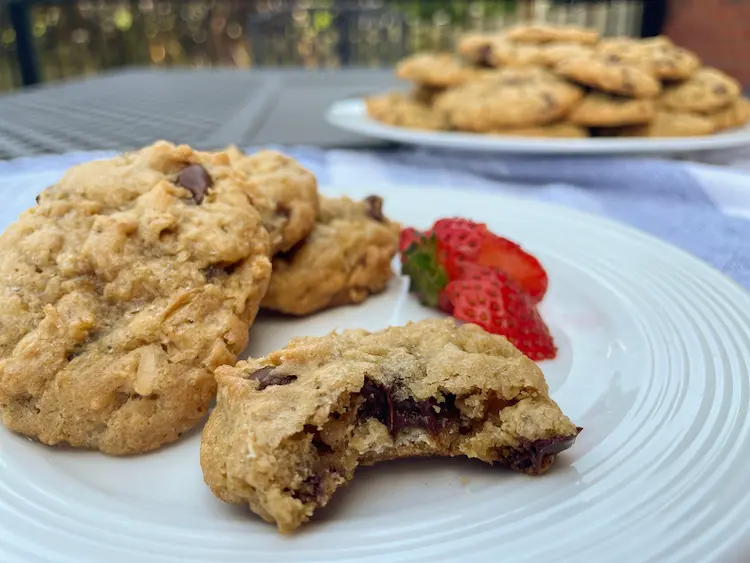 oatmeal cookies plated with a single strawberry. Plate of cookies in background. oatmeal cookies plated with a single strawberry. Plate of cookies in background.
