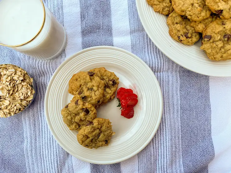 overhead shot of oatmeal cookies with cup of rolled oats and a glass of milk overhead shot of oatmeal cookies with cup of rolled oats and a glass of milk