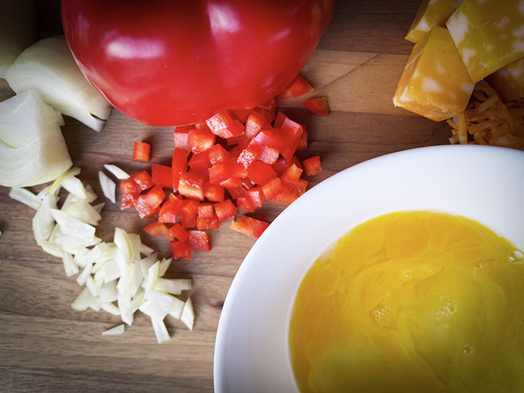 omelet with fillings ingredients.  eggs, red pepper, onion, cheese.