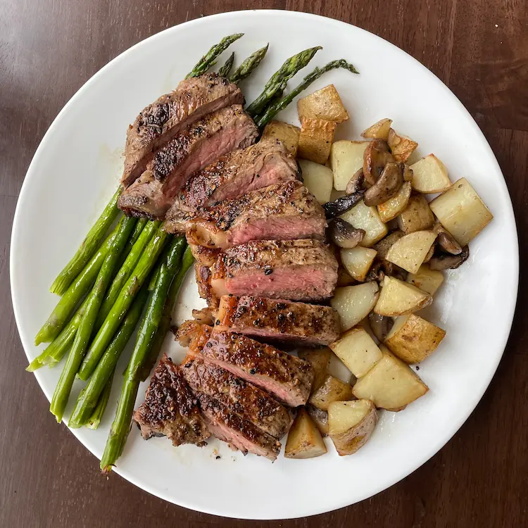 Overhead shot of a pan fried sirloin steak with potatoes and asparagus