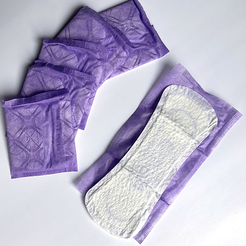 sanitary napkins in purple packets.  one open flat.