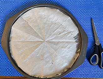 parchment lined pizza pan with scissors.