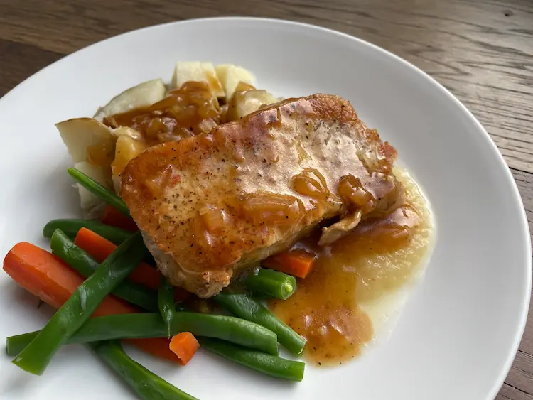 pork chops with gluten-free pan sauce plated with potato and vegetables