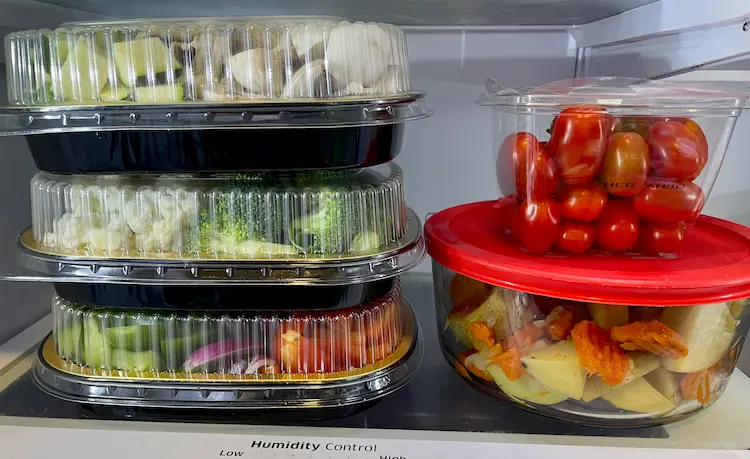 Meal prepped sheet pan ingredients in containers in the fridge.