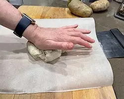 Press pizza dough into a 10" round Press pizza dough into a 10" round