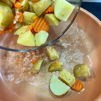 Potatoes and carrots in frying pan