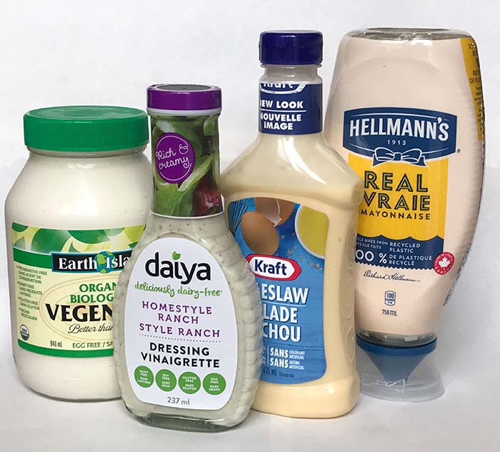 Four different salad dressings. Hellman's mayonnaise, vegan mayonnaise, vegan salad dressing and Kraft salad dressing. Four different salad dressings. Hellman's mayonnaise, vegan mayonnaise, vegan salad dressing and Kraft salad dressing.