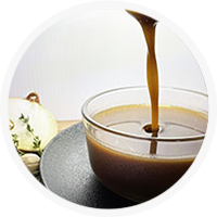 pouring brown sauce into a glass bowl